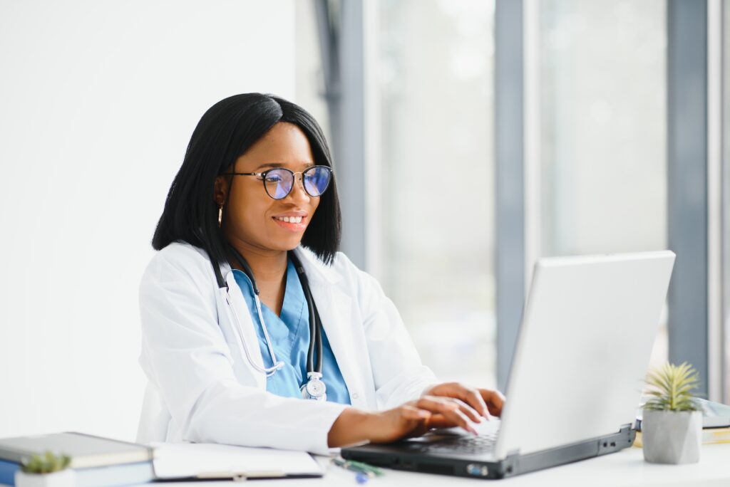 Young African-American doctor working on laptop in clinic - Trusted Consultants for a Practice Assessment​